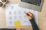 Designer sketching a website sitemap and page hierarchy showing navigation structure and site architecture